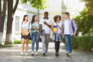 Group of multiethnic students walking together outdoors in college campus